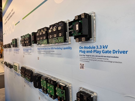 Foto zeigt eine Wand eines Messestandes, an der mehrere Elektronikbauteile auf einzelnen Acrylglassockeln an der Wand befestigt wurden.